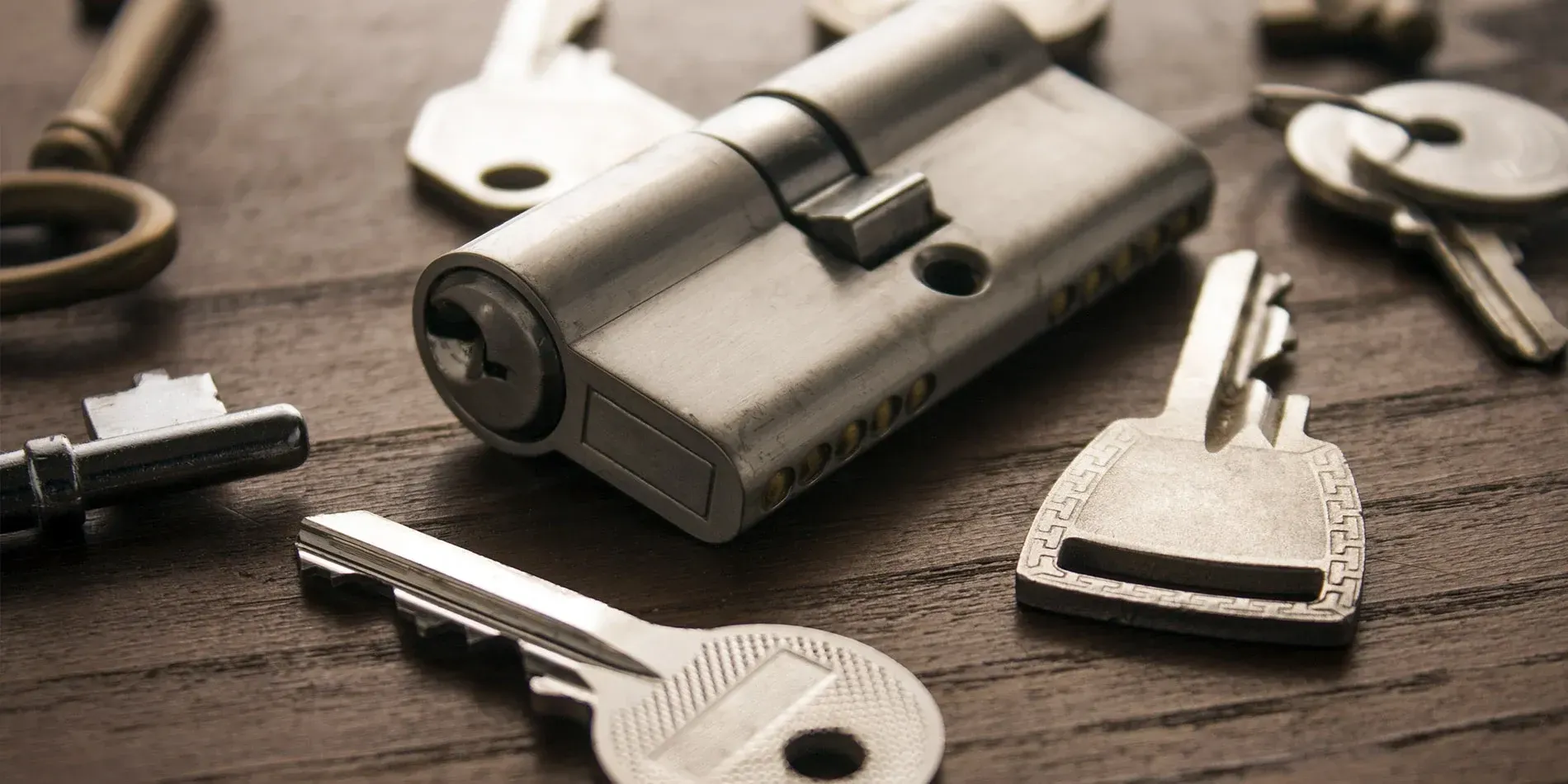 Keys and a lock cylinder on a workbench